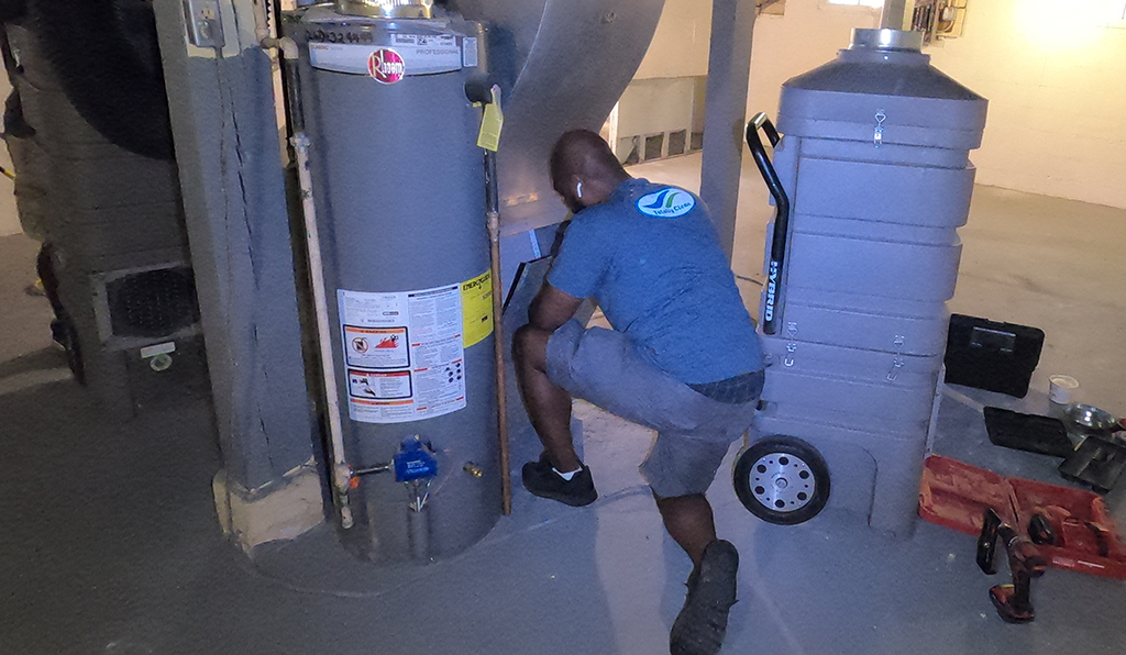 James Green from Totally Clean getting his HEPA rated vacuum connected to the furnace to start cleaning.